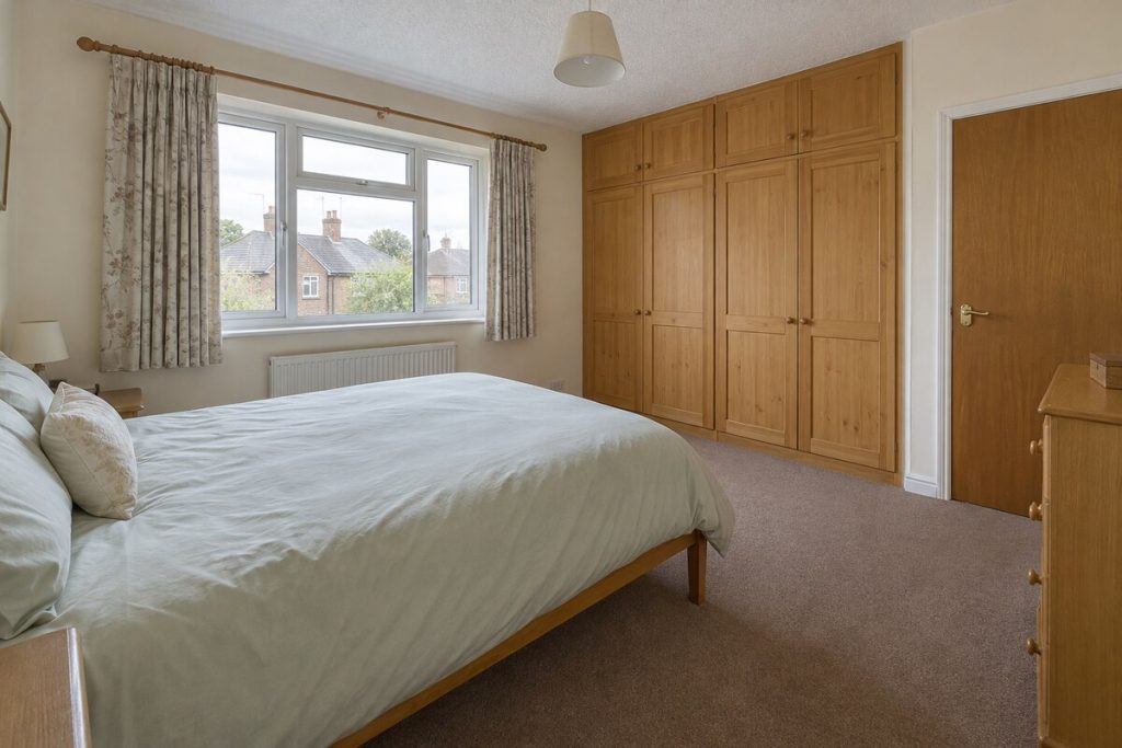 Bedroom in a dated but clean Victorian terrace, magnolia walls and older kitchen