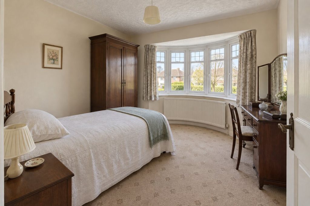 Bedroom in a dated but clean 1930s semi, magnolia walls and original kitchen