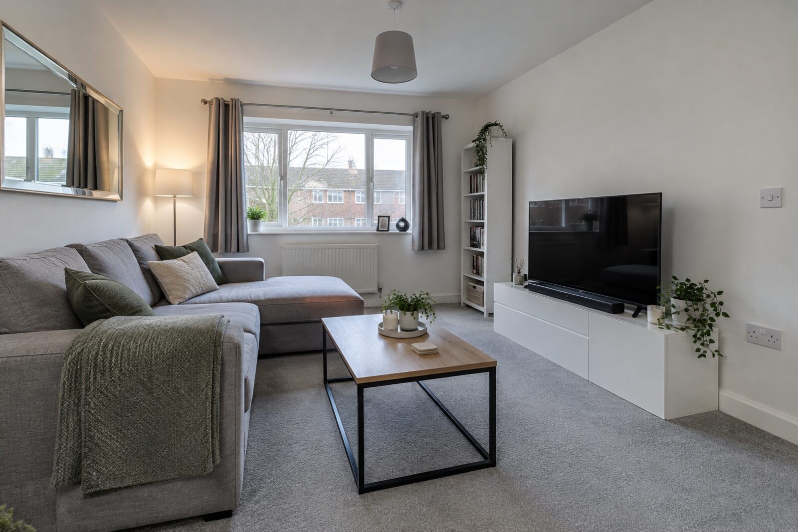 Living room in a refreshed 1990s flat with a white kitchen, winter light