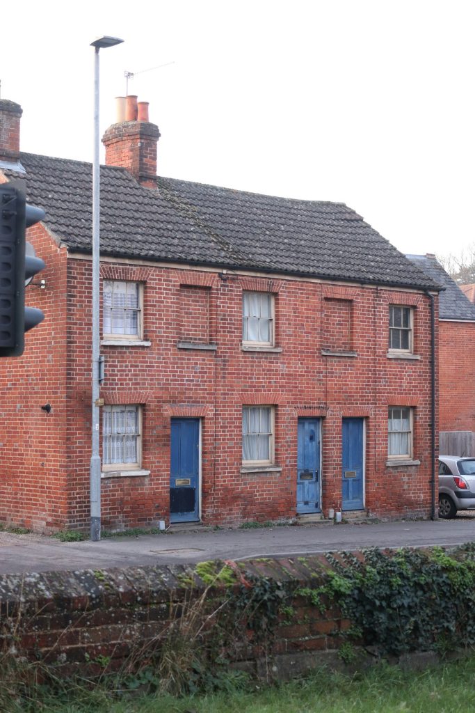 Pair of red brick Victorian terraced cottages with blue front doors