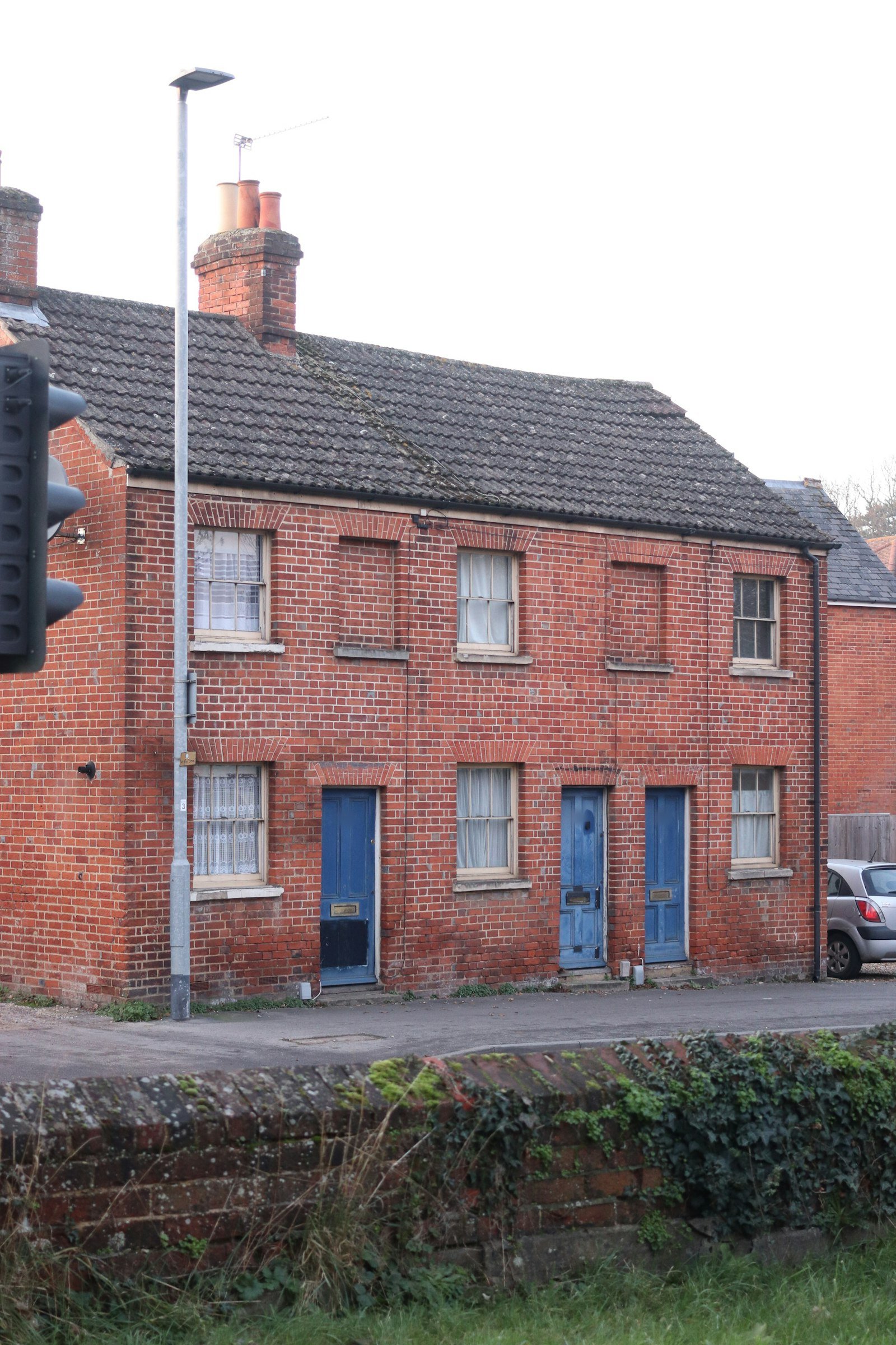 Pair of red brick Victorian terraced cottages with blue front doors