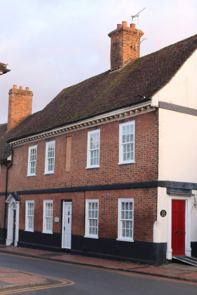 Georgian red brick terraced house with sash windows and a red front door