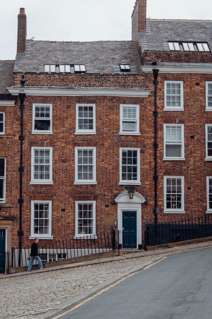 Tall Georgian red brick townhouse with sash windows and a green front door