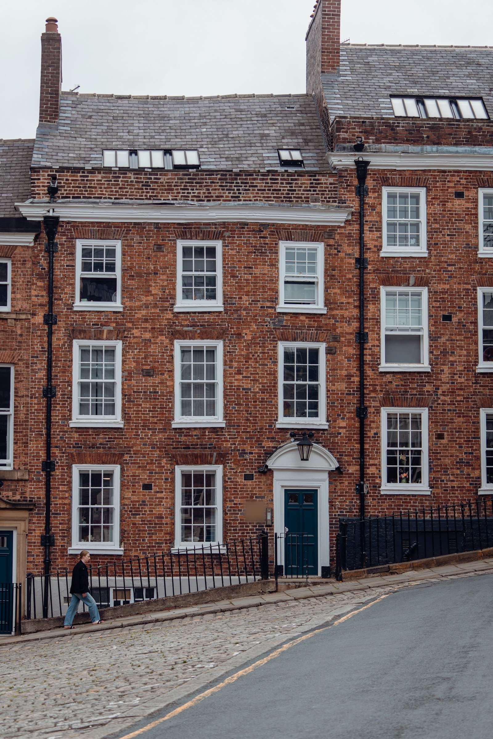 Tall Georgian red brick townhouse with sash windows and a green front door