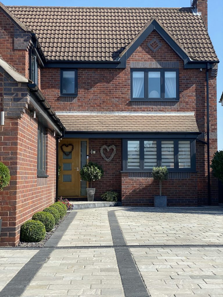 Modern red brick detached house with gabled front, tiled roof and block-paved drive