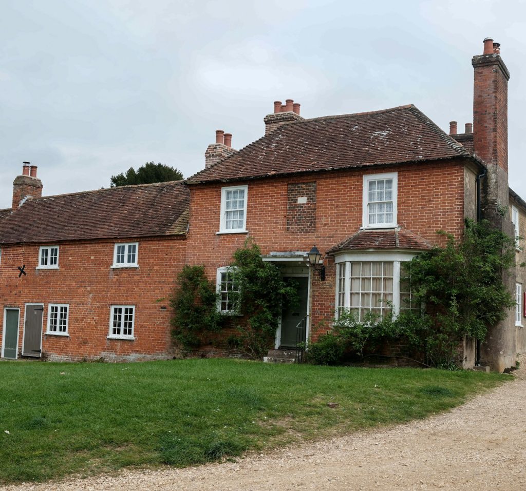 Red brick Georgian house with white sash windows, a bay and chimneys