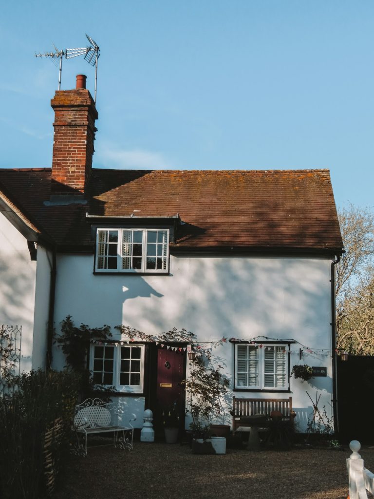 White rendered cottage with tiled roof and brick chimney