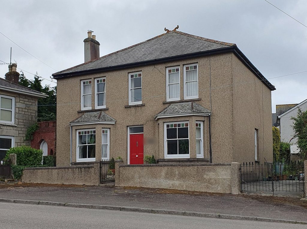 Pebbledash Edwardian detached house with twin bays, stained-glass sashes and a red front door