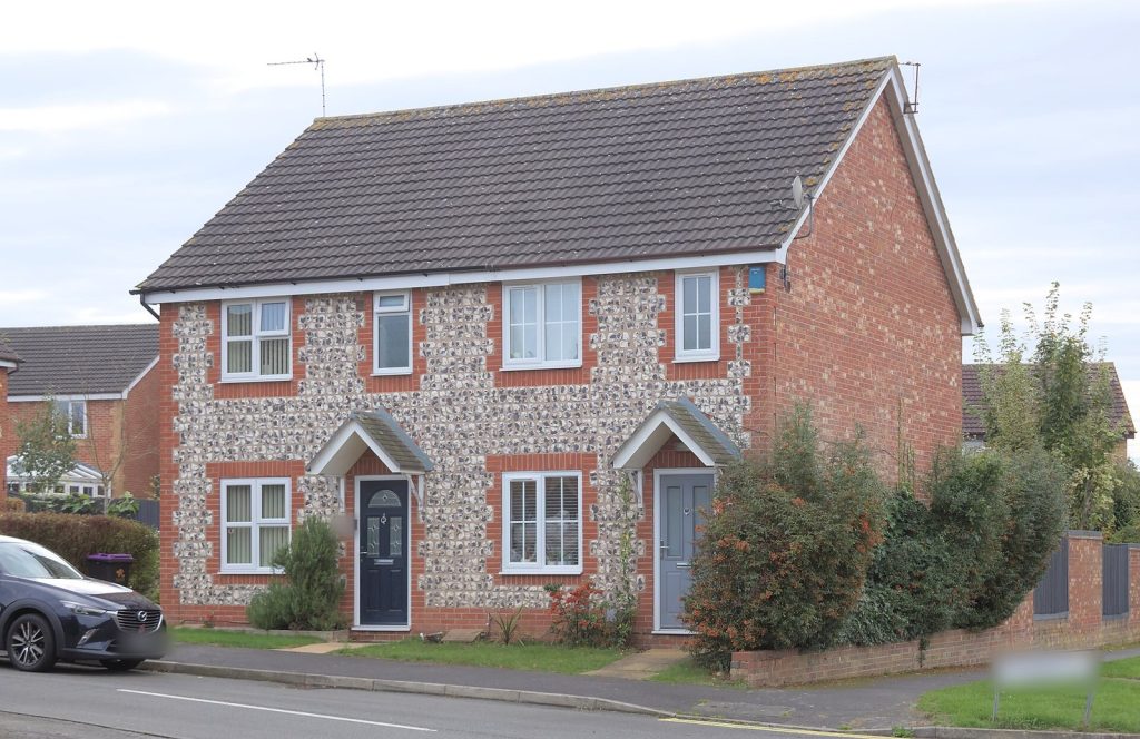 Modern semi-detached pair in red brick and flint with gabled porches and slate-grey doors, Nottinghamshire