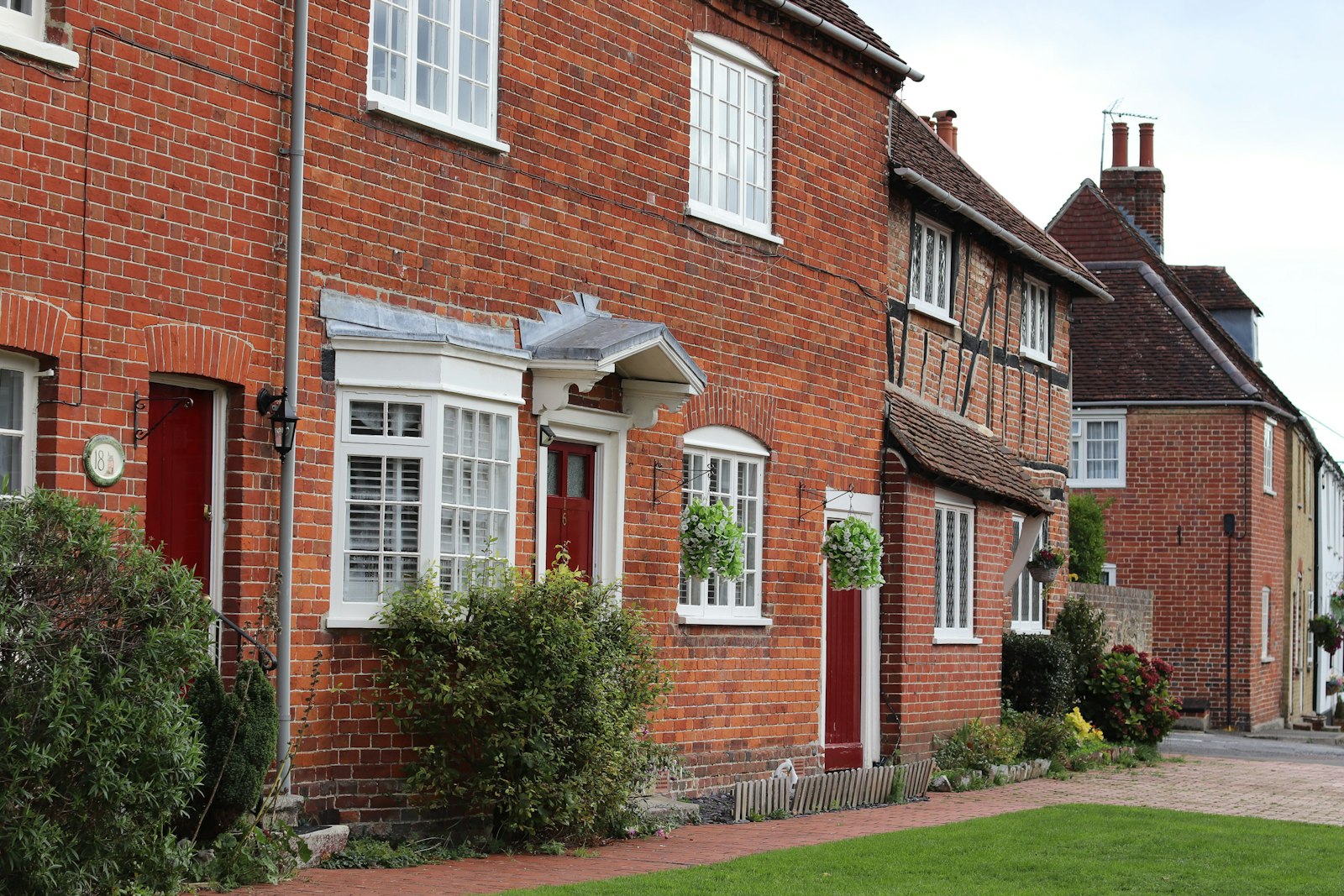 Brick terrace with red front doors and a bay window