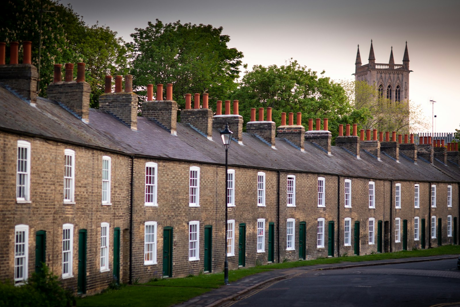 Long Victorian brick terrace seen from across a park