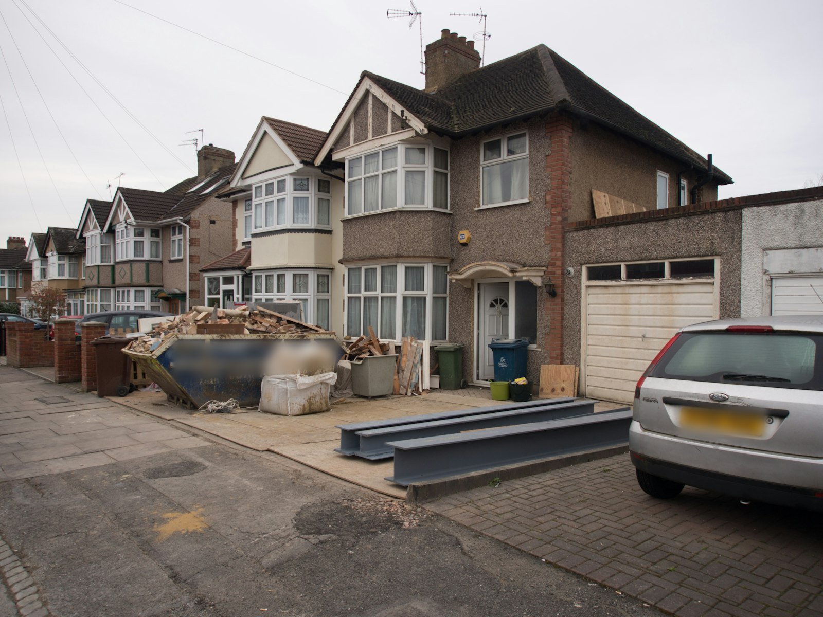 1930s brick semi-detached house with a car outside