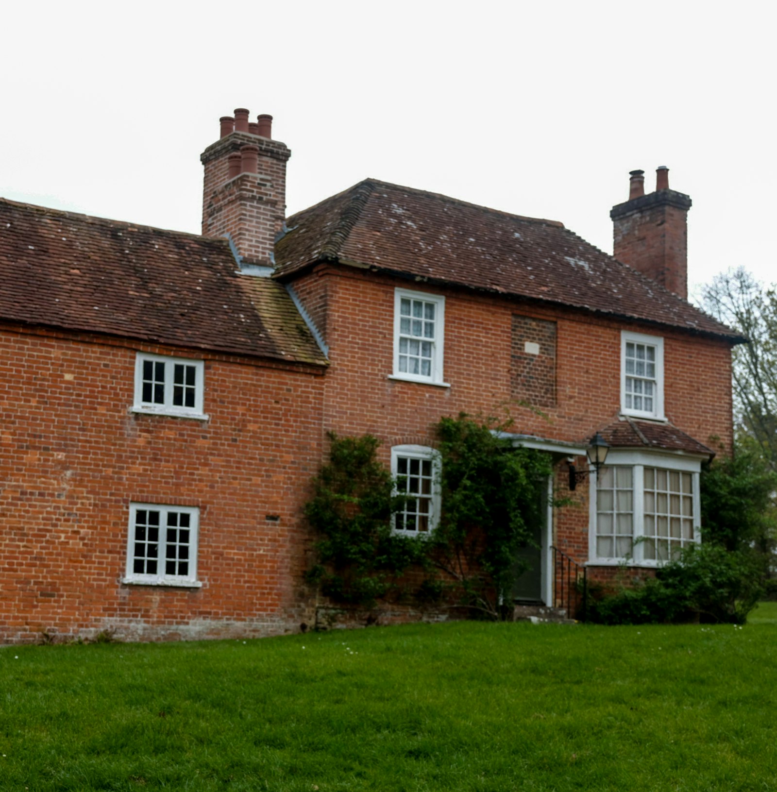 Georgian red brick house with white sash windows and a lawn
