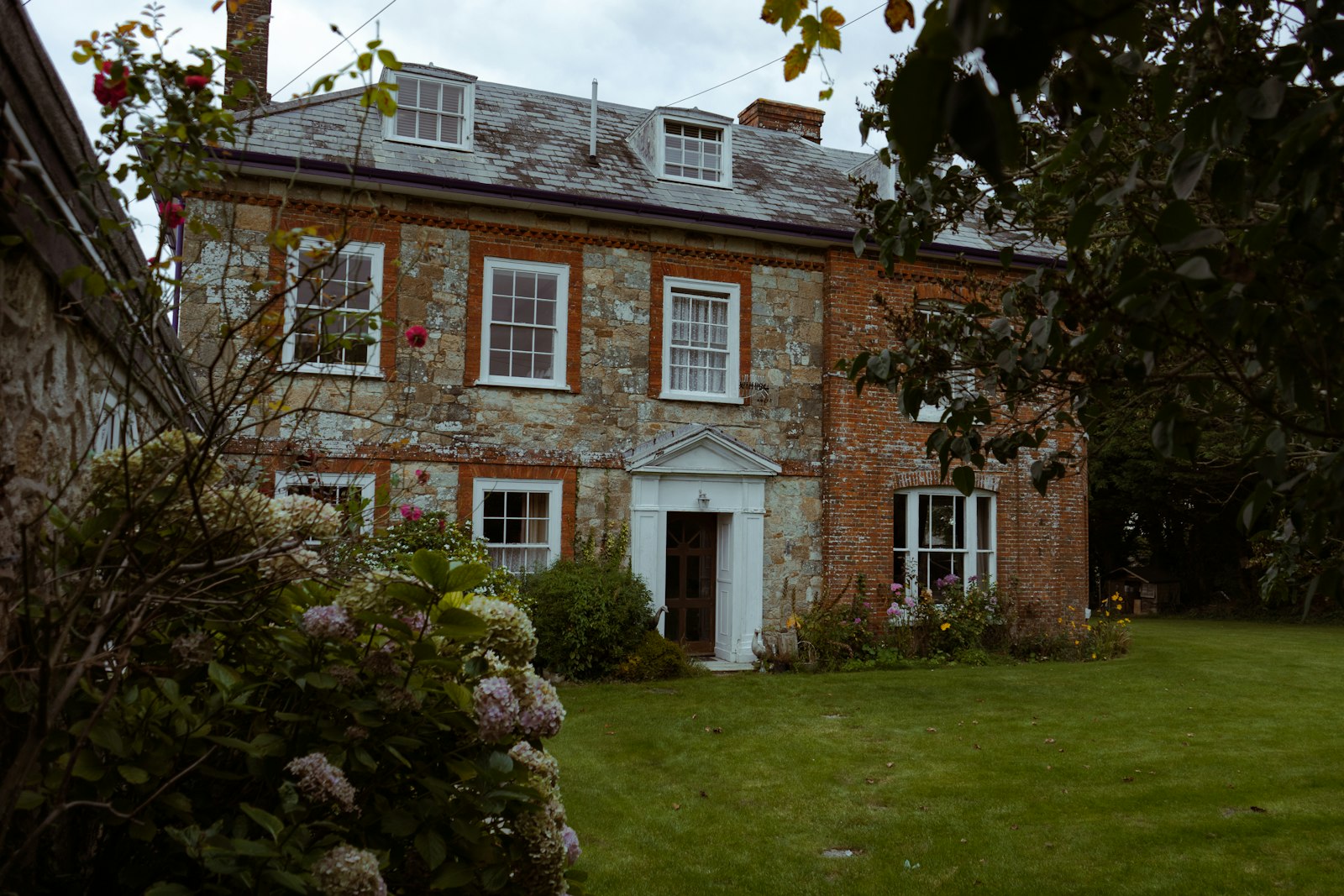 Georgian brick and flint house with a pedimented white door
