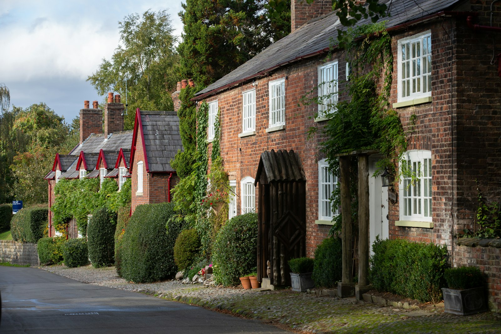 Brick cottages set among climbing plants