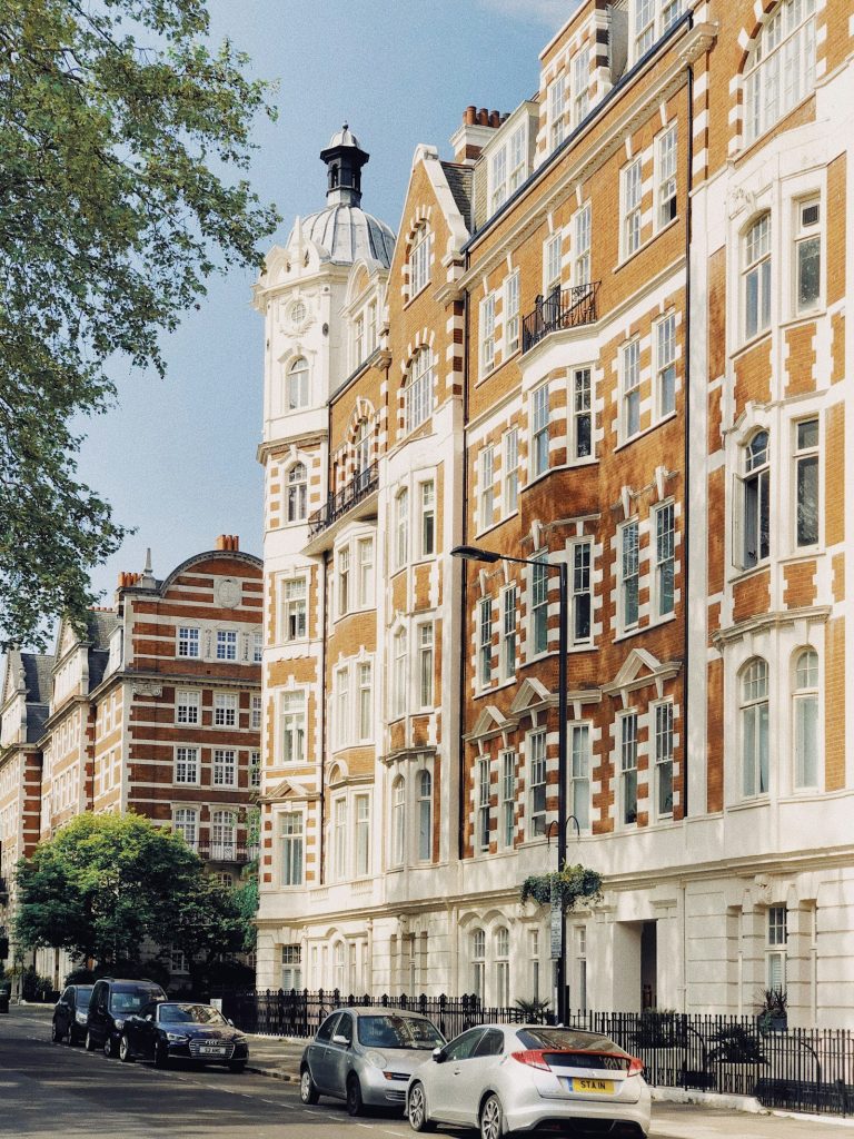 Edwardian mansion block with cars parked in front
