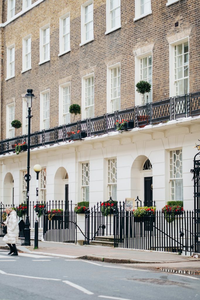 Georgian brick and stucco terrace with balconies, black railings and flower boxes
