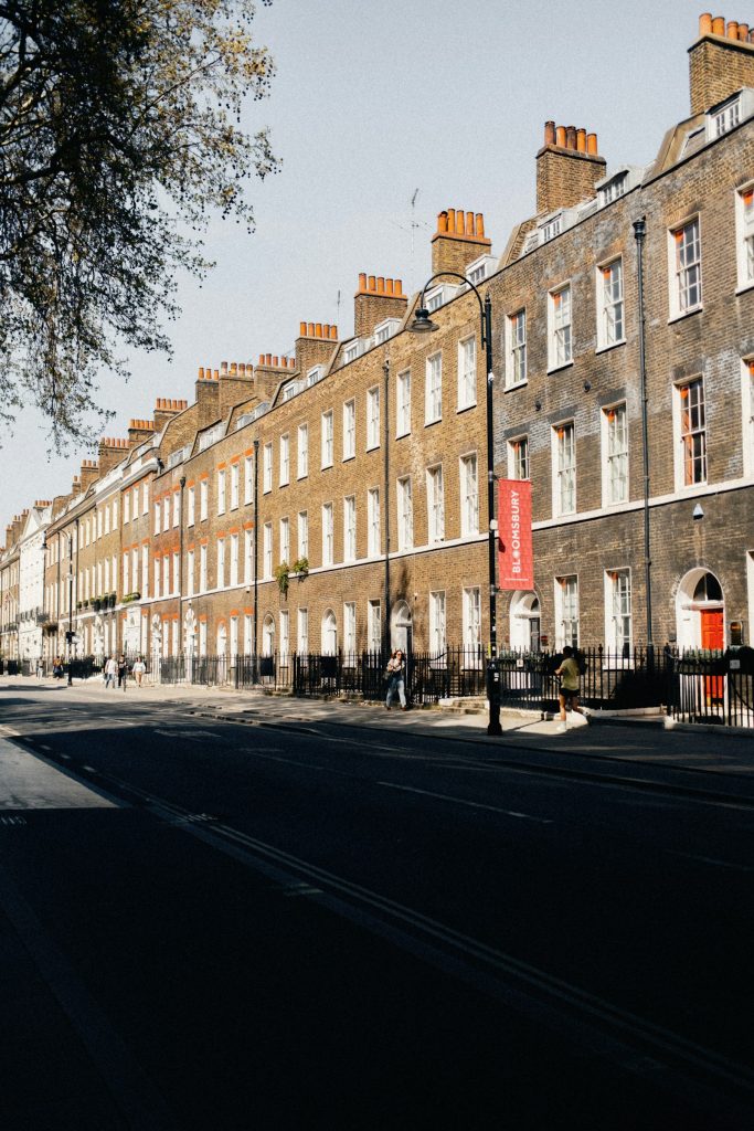Long Georgian brick terrace with orange chimney pots and a red front door